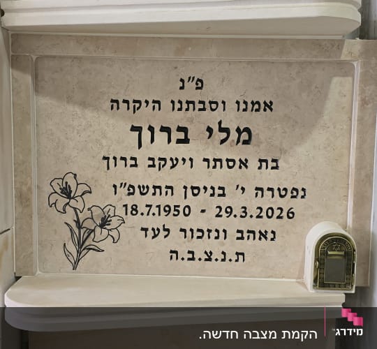 מצבה עם כיתוב בעברית ופרחים חקוקים